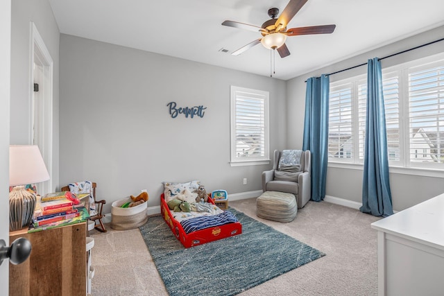 bedroom featuring baseboards, multiple windows, a ceiling fan, and carpet
