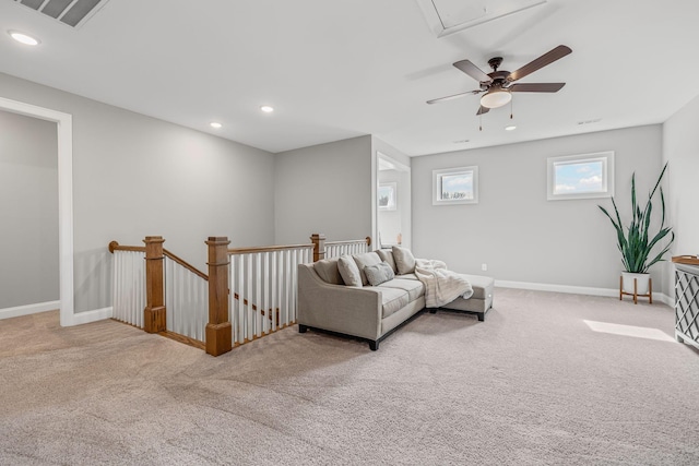 living area with light colored carpet, recessed lighting, visible vents, baseboards, and attic access