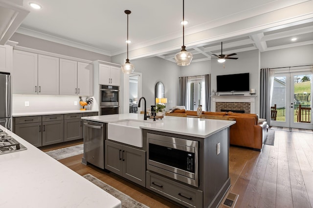 kitchen featuring light countertops, stainless steel appliances, white cabinetry, and a sink