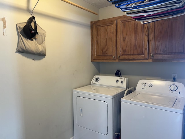 washroom featuring cabinet space and washer and clothes dryer