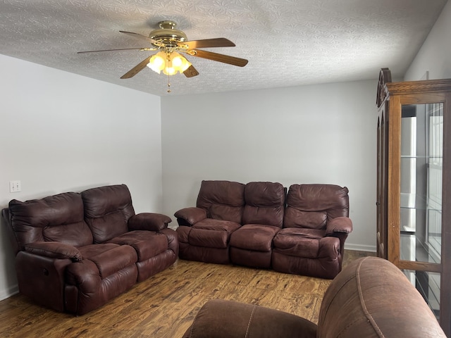 living room featuring a ceiling fan, a textured ceiling, and wood finished floors