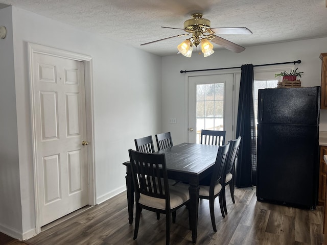 dining area featuring a textured ceiling, ceiling fan, dark wood-type flooring, and baseboards