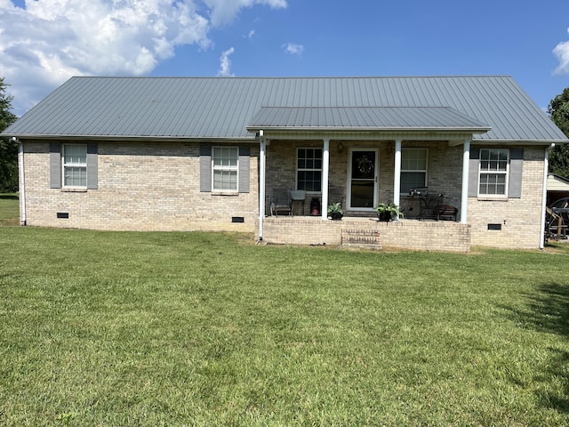 rear view of house featuring brick siding, covered porch, a yard, and crawl space