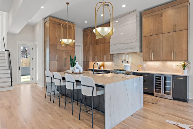 304 35th Ave N, Nashville, TN 37209 - kitchen with a kitchen island with sink, a breakfast bar area, a sink, wine cooler, and pendant lighting