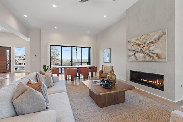 304 35th Ave N, Nashville, TN 37209 - living area featuring baseboards, a glass covered fireplace, recessed lighting, light wood-type flooring, and a towering ceiling