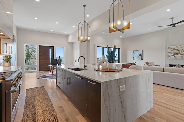 304 35th Ave N, Nashville, TN 37209 - kitchen featuring high end stove, hanging light fixtures, open floor plan, a sink, and a large island with sink