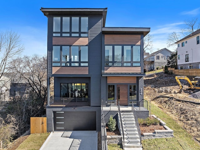 304 35th Ave N, Nashville, TN 37209 - modern home featuring stairway, an attached garage, fence, driveway, and brick siding