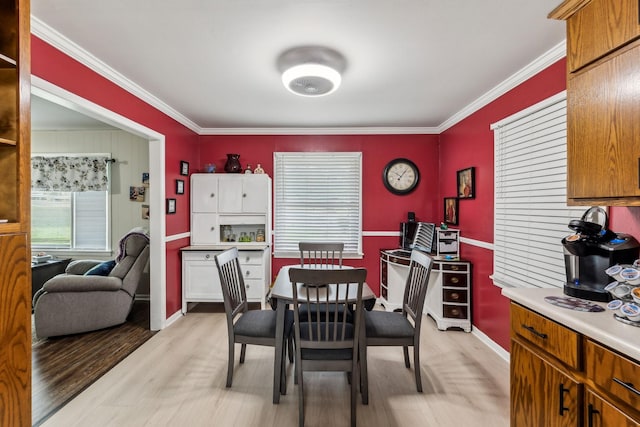 dining room with baseboards, light wood-style flooring, and ornamental molding