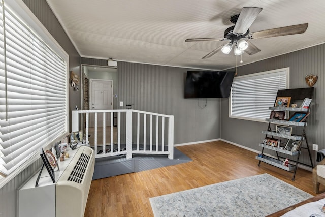 interior space with ornamental molding, baseboards, and wood finished floors