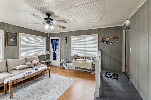 living area featuring crown molding, a ceiling fan, and wood finished floors