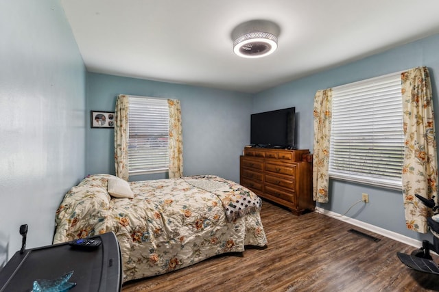 bedroom featuring dark wood finished floors, baseboards, and visible vents