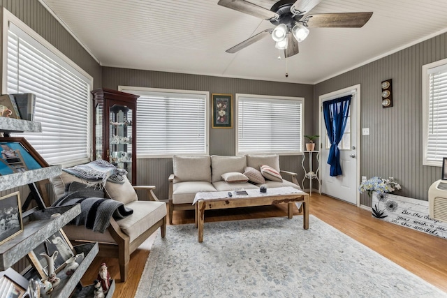 living area featuring crown molding, a ceiling fan, and wood finished floors