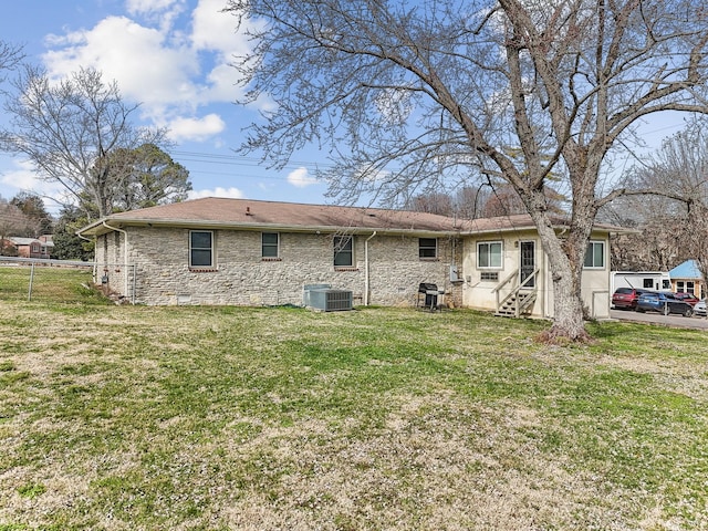 rear view of property featuring fence, central air condition unit, a yard, and crawl space