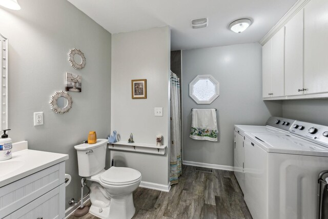 washroom with baseboards, visible vents, separate washer and dryer, dark wood-type flooring, and laundry area