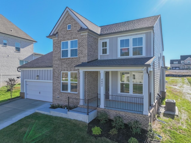 traditional home featuring covered porch, an attached garage, board and batten siding, concrete driveway, and brick siding