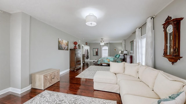 living area featuring dark wood-style flooring, baseboards, and a ceiling fan