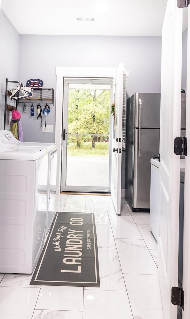 laundry room with laundry area, visible vents, marble finish floor, and separate washer and dryer