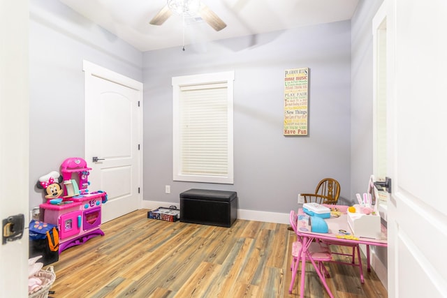 rec room featuring baseboards, a ceiling fan, and wood finished floors