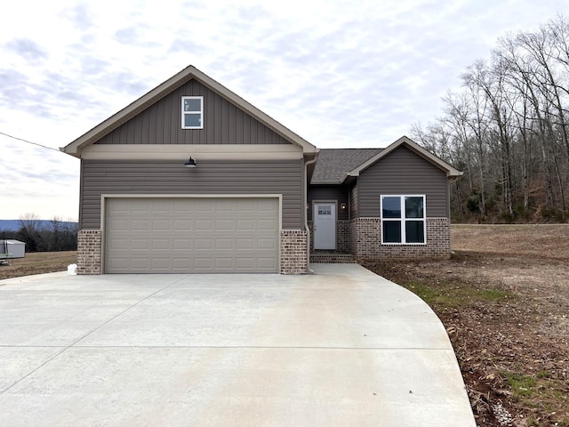 craftsman-style house featuring concrete driveway, board and batten siding, a garage, and brick siding