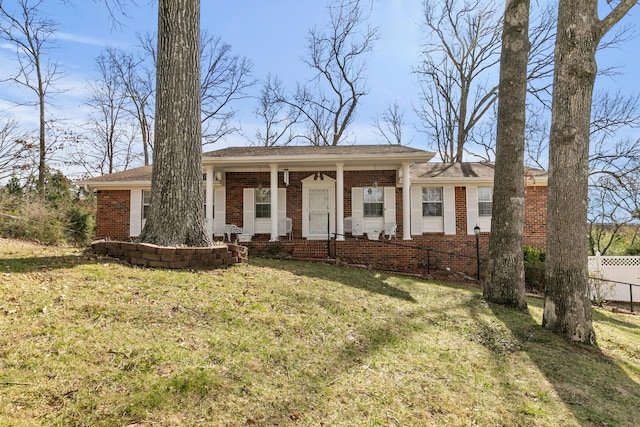 ranch-style home featuring a front yard, fence, and brick siding