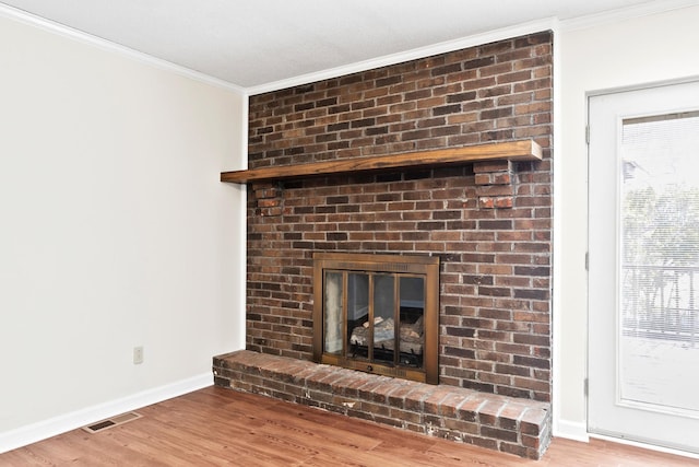 room details featuring a fireplace, visible vents, wood finished floors, and ornamental molding