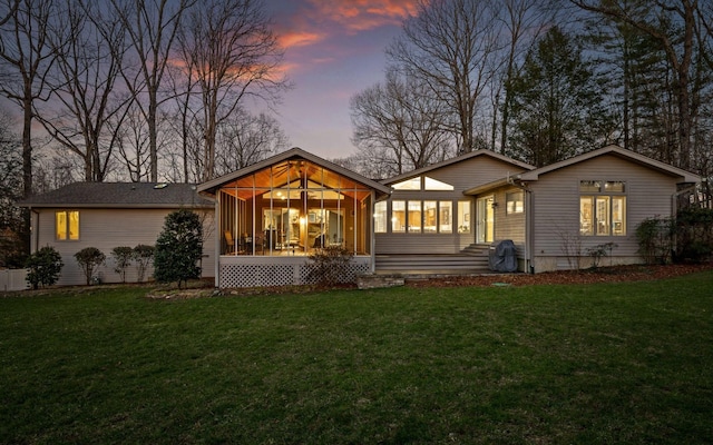 back of house featuring a sunroom and a yard