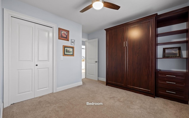 unfurnished bedroom with light colored carpet, ceiling fan, a closet, and baseboards