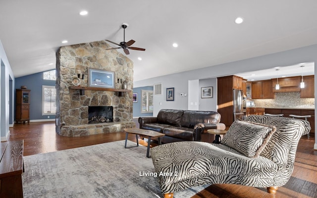 living area featuring recessed lighting, dark wood-style floors, baseboards, a stone fireplace, and ceiling fan