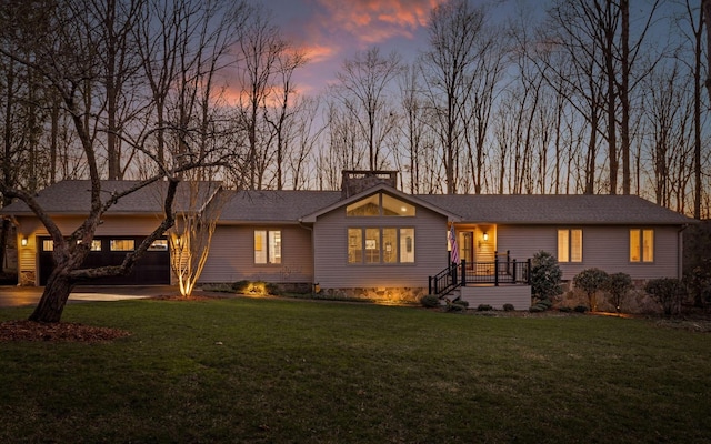 view of front of home with driveway, a shingled roof, a chimney, and a lawn