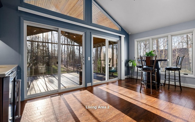 entryway with dark wood-style floors, visible vents, baseboards, and high vaulted ceiling