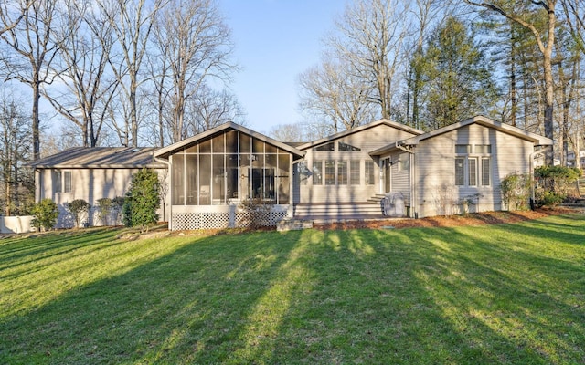 rear view of house featuring a sunroom and a yard