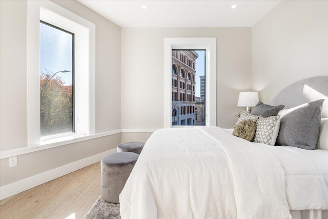 bedroom with baseboards, wood finished floors, and recessed lighting