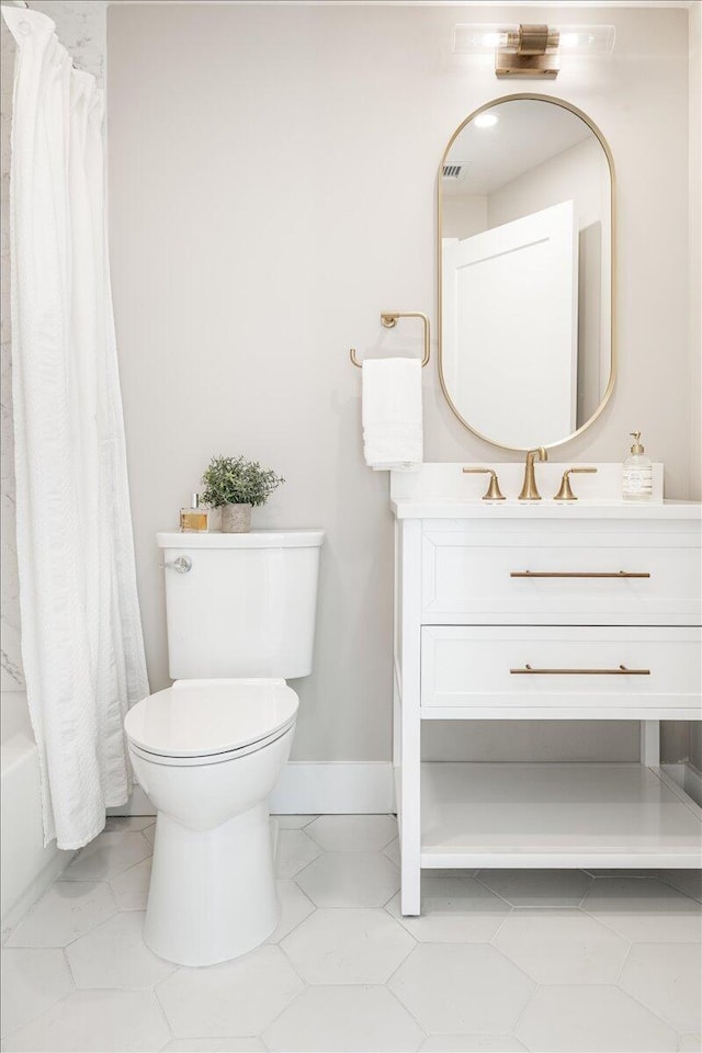 bathroom featuring toilet, baseboards, vanity, and shower / tub combo with curtain