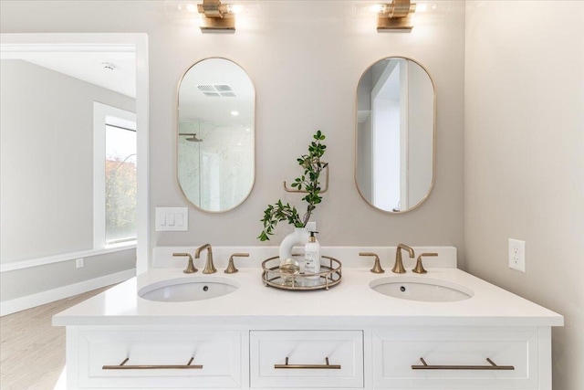 bathroom featuring double vanity, visible vents, and a sink