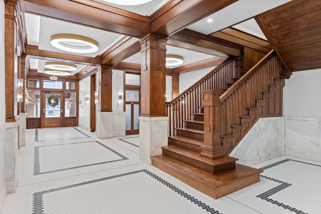 foyer featuring ornate columns, stairway, french doors, and wainscoting