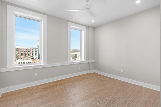 empty room with baseboards, recessed lighting, a ceiling fan, and light wood-style floors