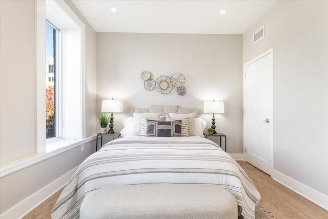 bedroom featuring light wood finished floors, visible vents, baseboards, and recessed lighting