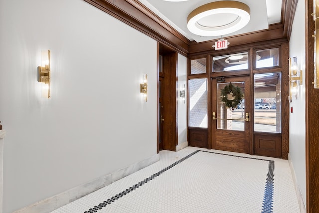 entryway featuring baseboards and crown molding