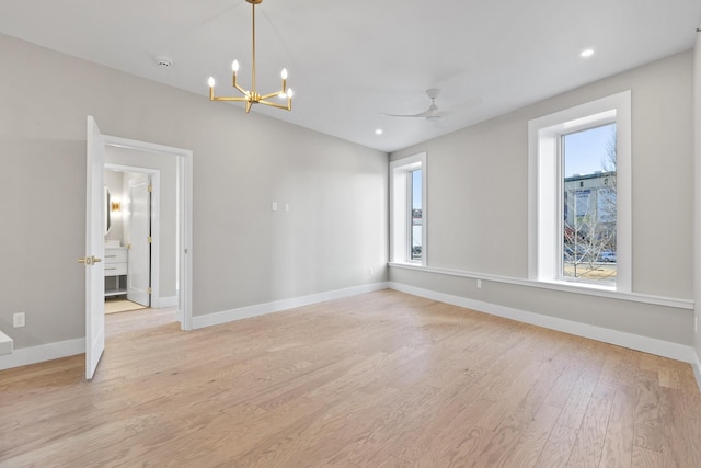 spare room featuring light wood-style flooring, baseboards, and a wealth of natural light