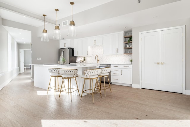 kitchen with light countertops, open shelves, white cabinetry, and appliances with stainless steel finishes