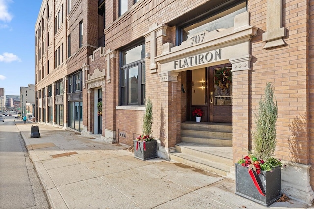 property entrance featuring brick siding and crawl space