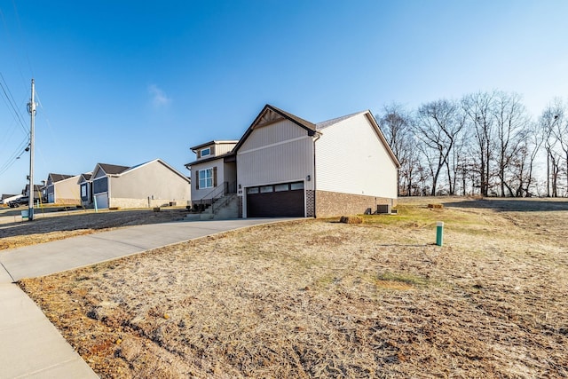 view of front of house featuring a front yard, driveway, a garage, and brick siding