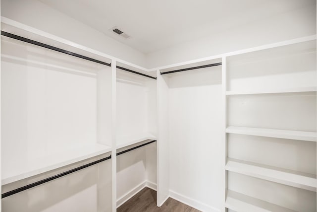 spacious closet featuring visible vents and dark wood finished floors