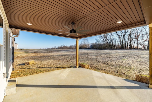 view of patio with ceiling fan and a rural view