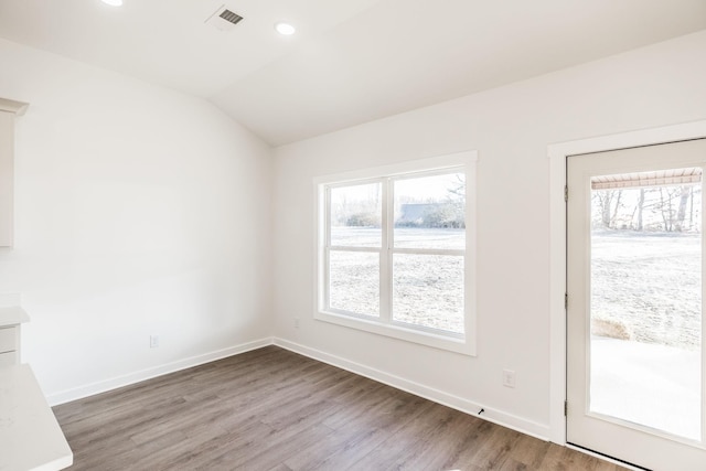 empty room with recessed lighting, wood finished floors, visible vents, baseboards, and vaulted ceiling