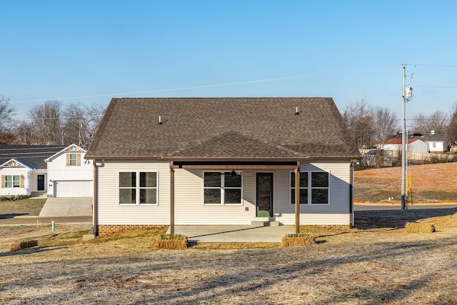 view of front of property with a shingled roof and a patio