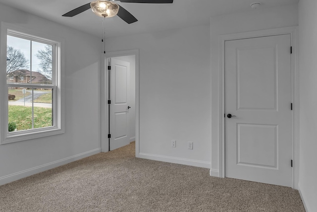 unfurnished bedroom featuring carpet floors, baseboards, and a ceiling fan