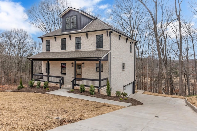 traditional style home with covered porch, concrete driveway, brick siding, and a garage