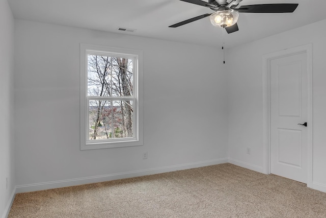 carpeted empty room featuring a ceiling fan, a healthy amount of sunlight, visible vents, and baseboards