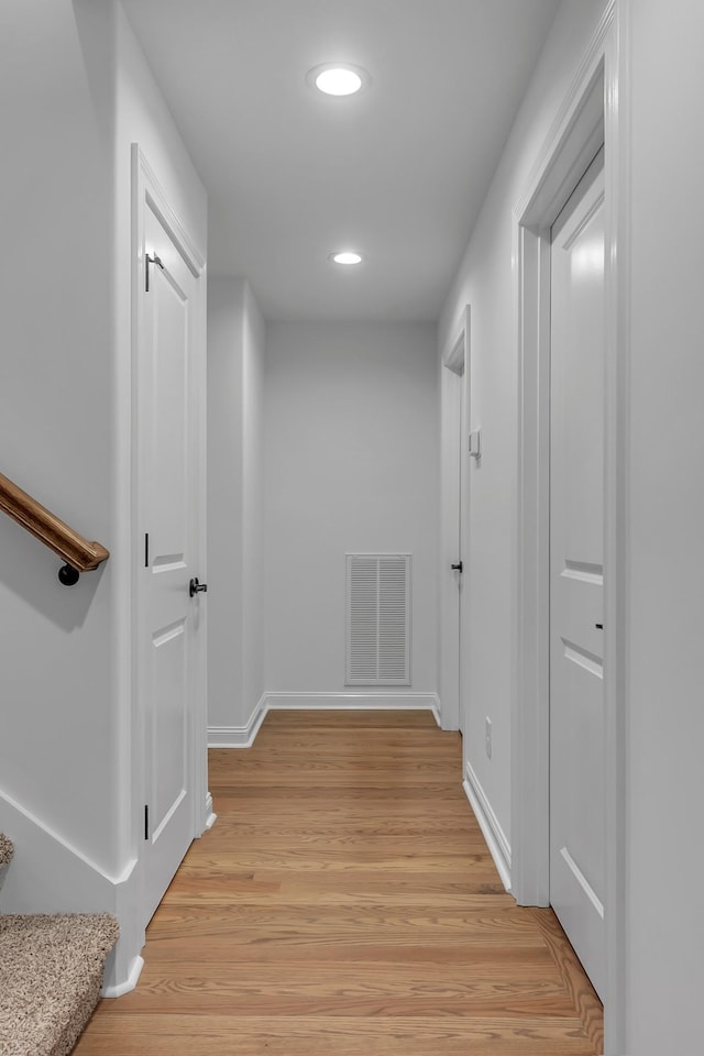 hall with light wood-style floors, recessed lighting, visible vents, and baseboards